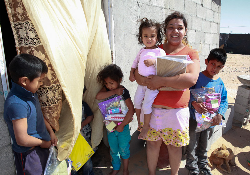 Mexican families holding care packs